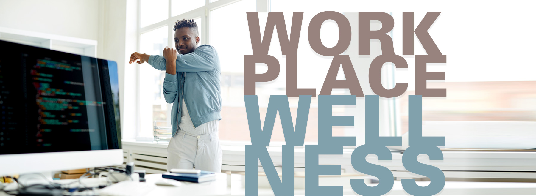 African American man stretching at desk with the title "Workplace Wellness"